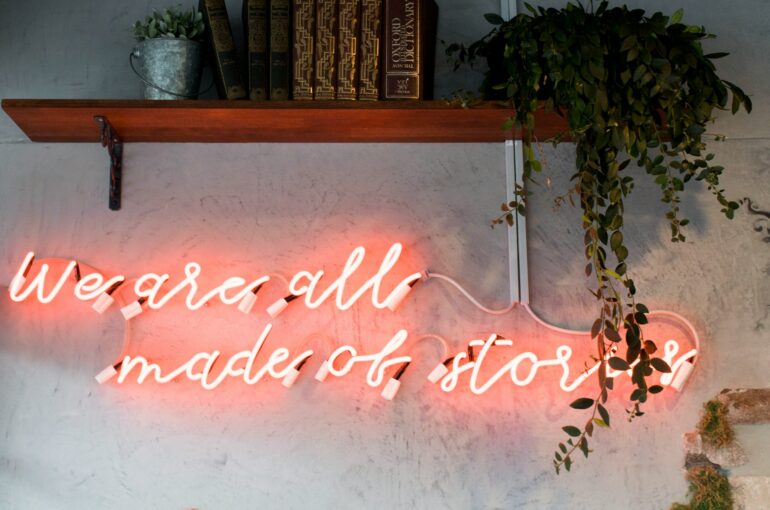 Neon lighting on a wall that says "We are all made of stories"