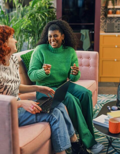 Two women sat on sofa talking